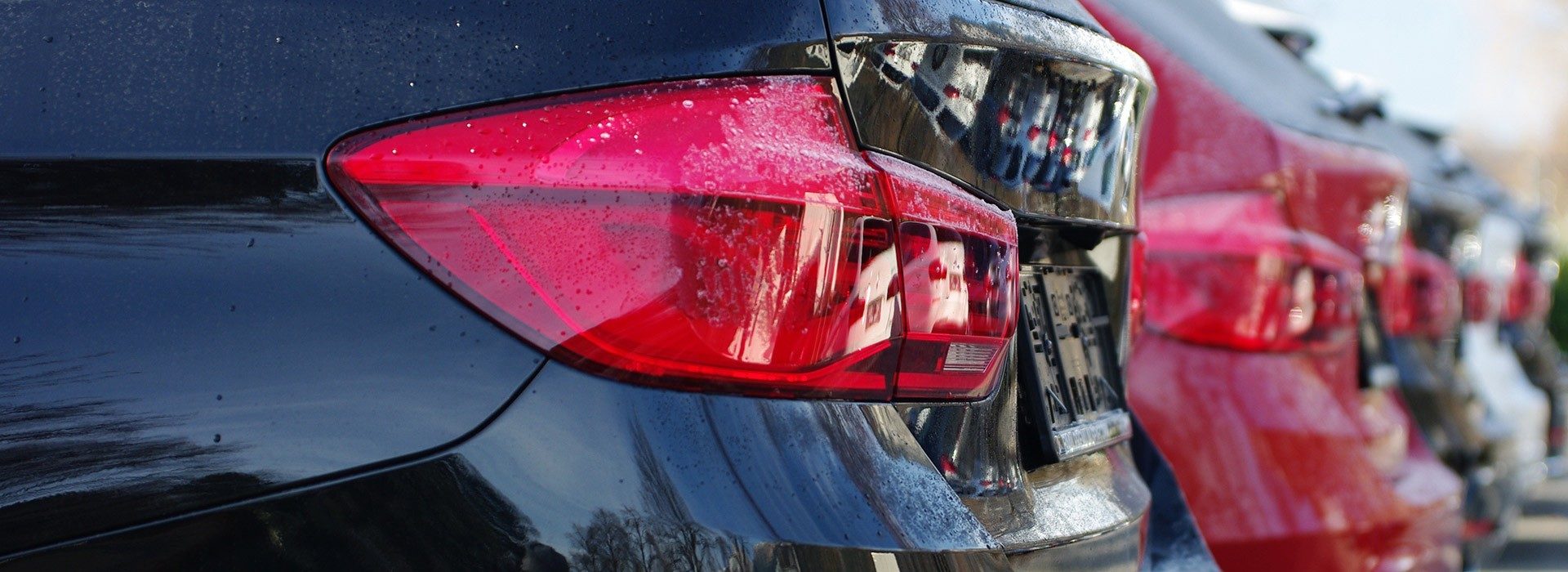 Reihe frisch aufbereiteter Fahrzeuge mit spiegelndem Lack nach der Lackierung